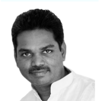 Krupaashangar, in a white kurta, looking straight at the camera in black and white.
